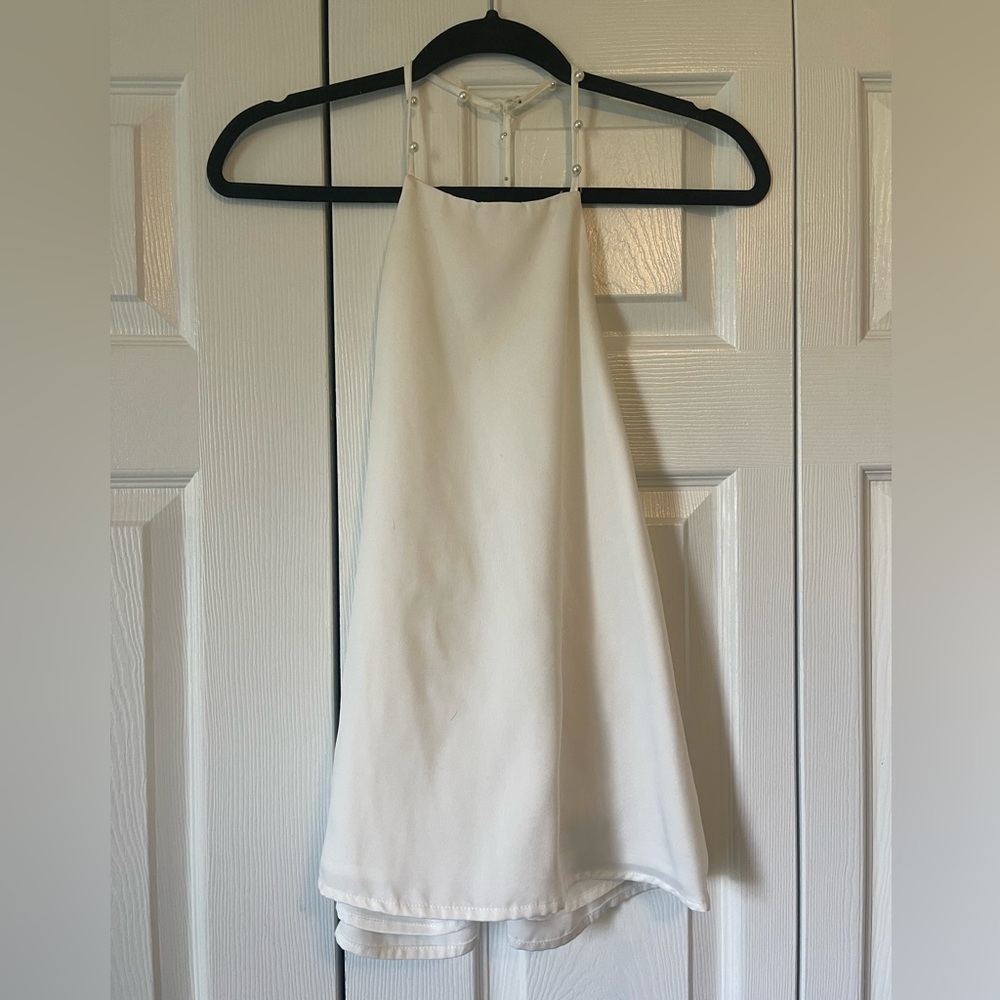 Open back white tank top with pearls.